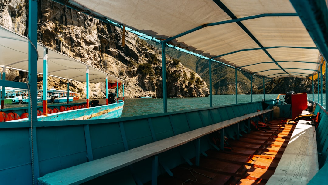 Inside a boat with benches, overlooking water.